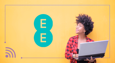 Woman holding laptop looking up at EE logo